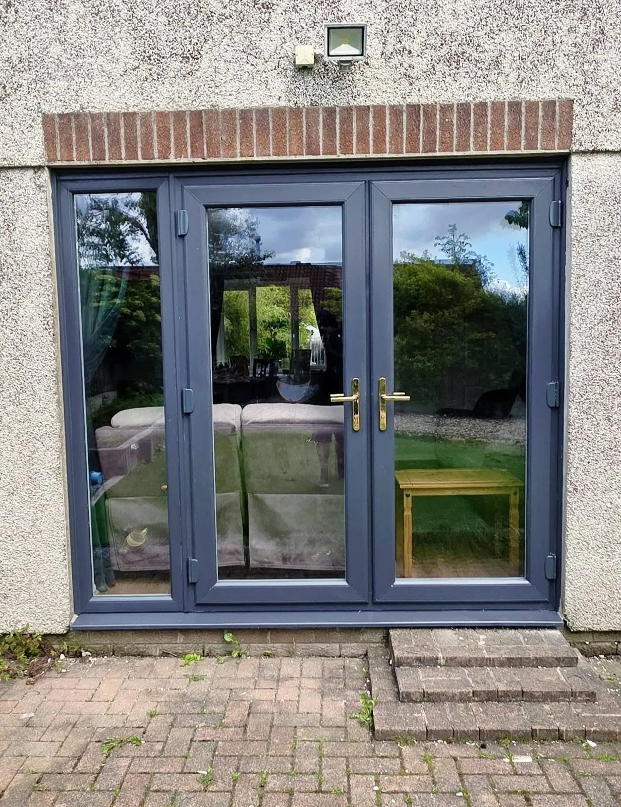 Anthracite grey uPVC French doors fitted to the rear of a rendered house