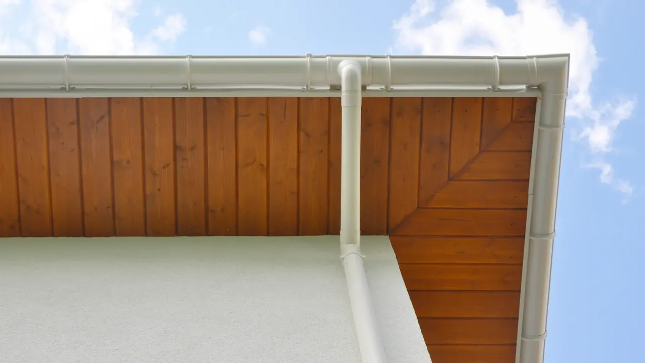White uPVC guttering and downpipe under a timber soffit