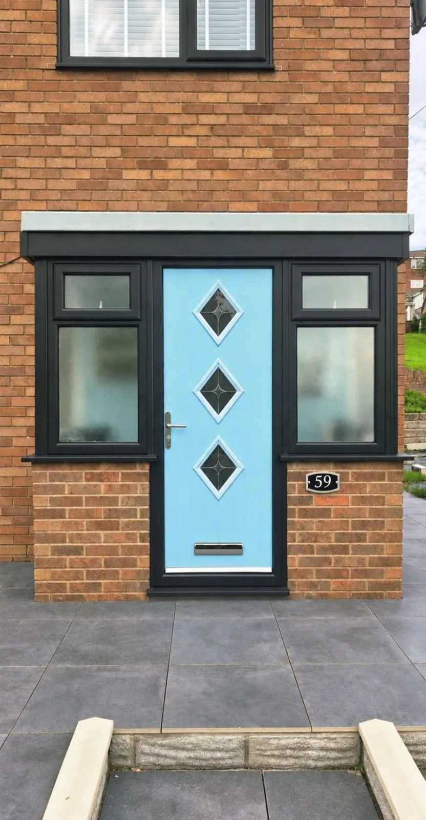 Pastel blue composite door with diamond glazing in an anthracite porch frame