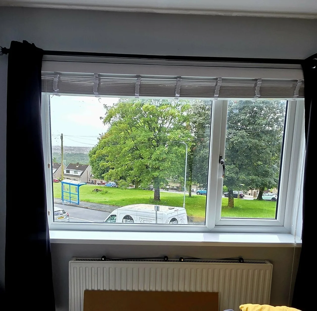 White uPVC window overlooking trees, interior view