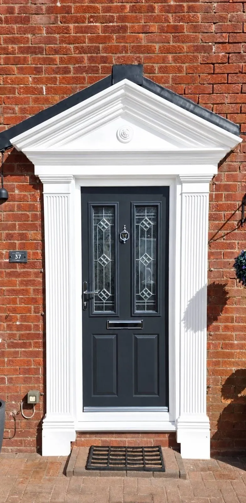 Anthracite grey composite front door with decorative glass under a white portico, South Wales