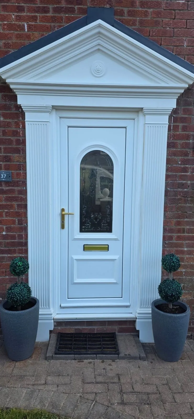 Old white front door under a portico before composite door replacement