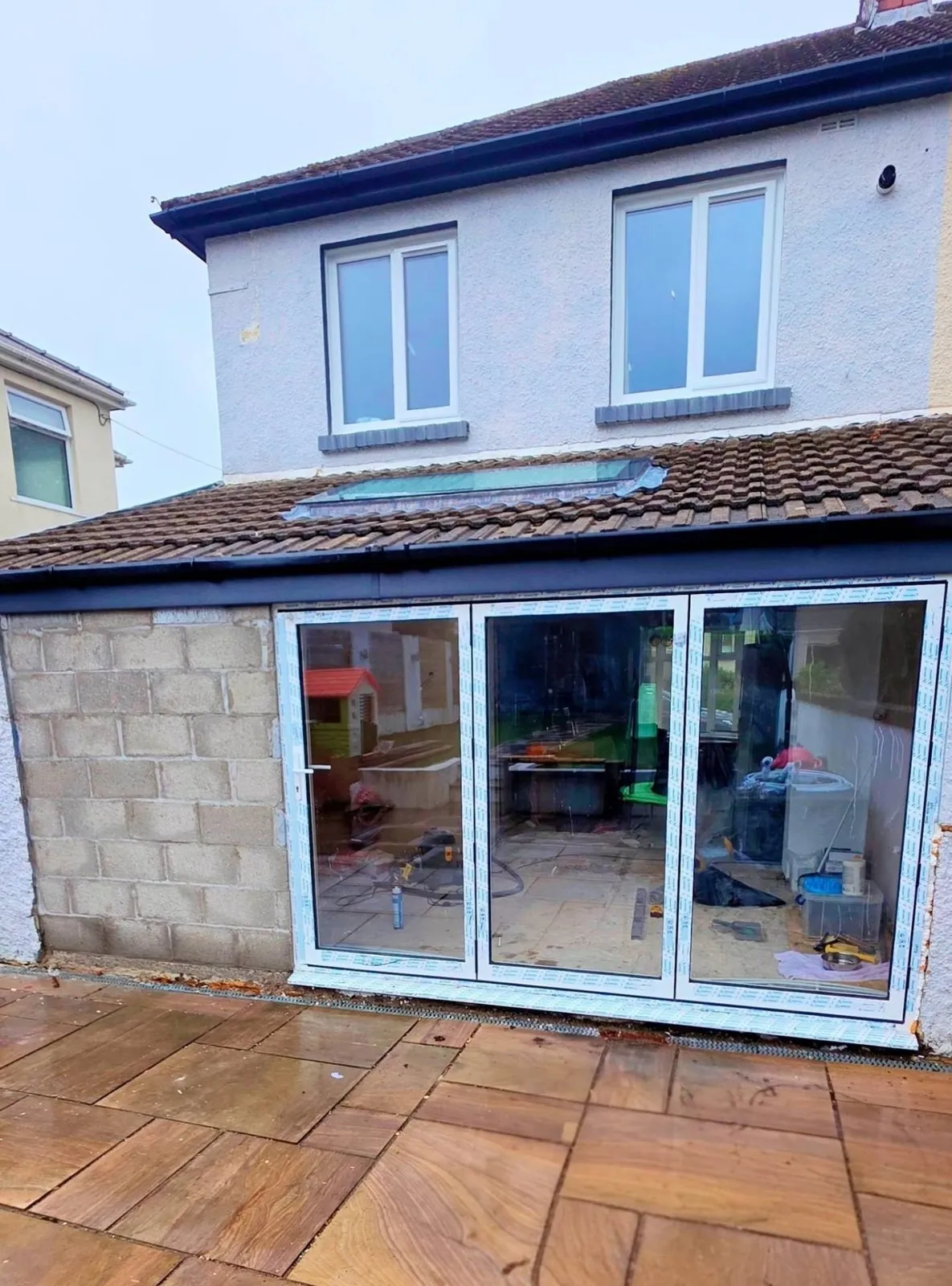 White bifold doors being installed on a rear extension