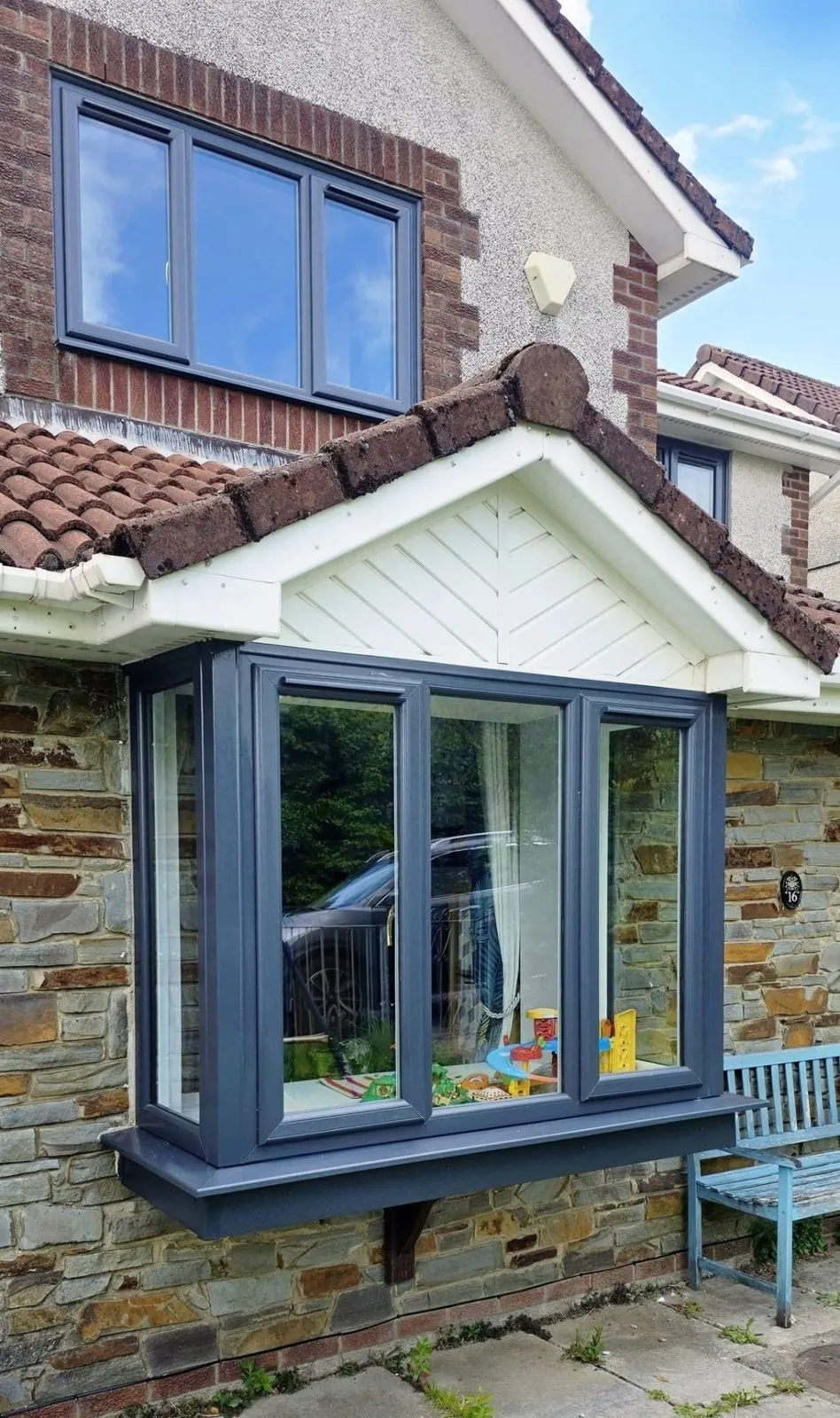 Anthracite grey bay window fitted to a stone-fronted house