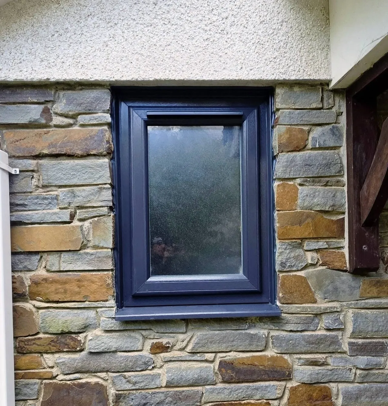 Anthracite window with obscure glass fitted in a stone wall