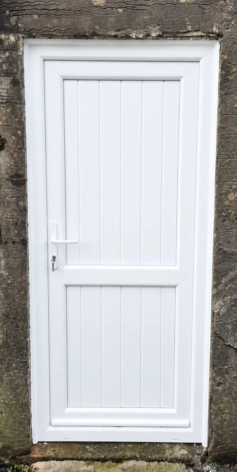 White uPVC panel back door fitted into a stone wall